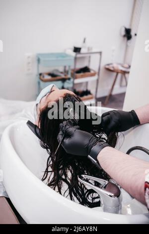 close-up of stylist using hair dye at salon Stock Photo