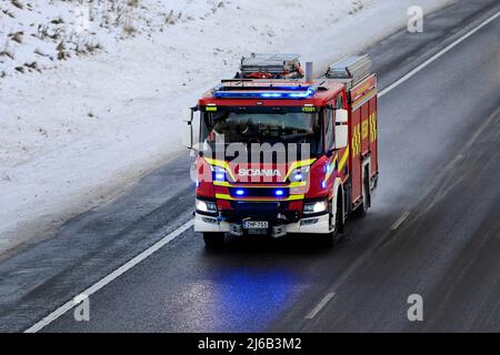 Scania P CrewCab fire truck on call with blue lights flashing, at speed on motorway on a day of winter. Salo, Finland. December 31, 2021. Stock Photo