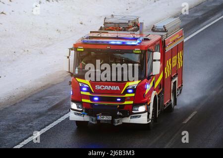 Scania P CrewCab fire truck on call with blue lights flashing, at speed on motorway on a day of winter. Salo, Finland. December 31, 2021. Stock Photo