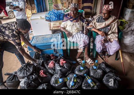 Somali men gather Ramadan packages of rice, cooking oil and other essentials for families in need, outside a shop in Dollow, Jubaland, southwest Somalia. (Photo by Sally Hayden / SOPA Images/Sipa USA) Stock Photo