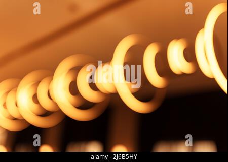 blurred hanging lamp bulb in the form of rings. blur beautiful abstract lighting under the ceiling from modern pendant electricity round lamps chandel Stock Photo