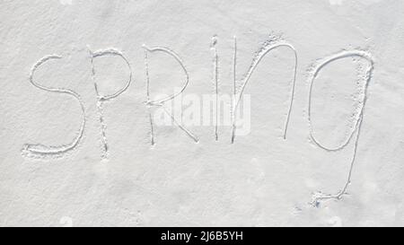 'Spring' text written on virgin snow. Top aerial view Stock Photo