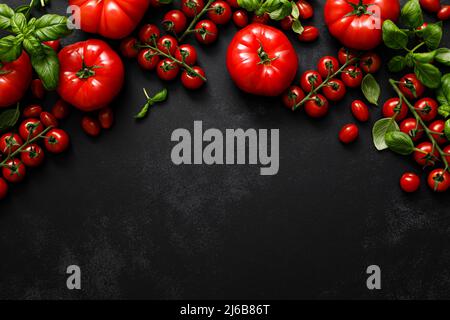 Tomatoes and basil on black background, top view, flat lay Stock Photo