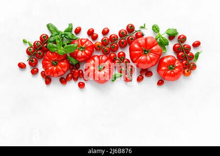 Tomatoes and basil on white background, top view, flat lay Stock Photo