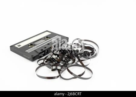 This shows a well known problem with the old fashioned compact cessettes: the tape used to come out, making the cassette useless Stock Photo