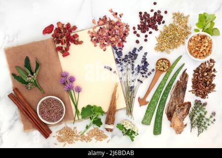 Herbal plant medicine and flower remedy preparation with herbs and flowers with old hemp notebook. Natural health care concept for alternative healing Stock Photo