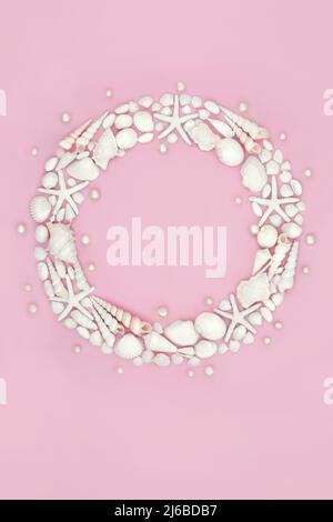 Sea shell wreath with collection of white shells and oyster pearls. Nature summer marine life concept. Top view, copy space on pink background. Stock Photo