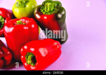red and green sweet bell peppers on a purple background, fresh juicy vegetables on a colored background, selective focus, soft focus Stock Photo