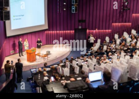 Defocused image of speakers giving a talk at business meeting Stock Photo