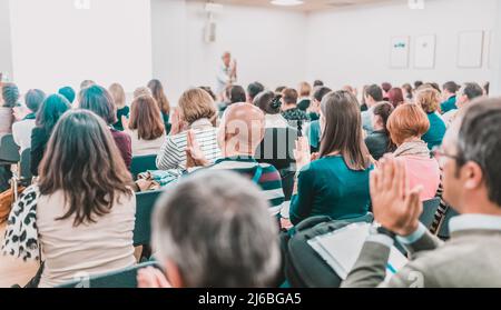 Woman giving interactive motivational speech at entrepreneurship workshop. Stock Photo