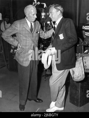 Director HOWARD HAWKS and HARRY CAREY Jr. (playing uncredited cameo as member of Olympic Team) on set candid during filming of GENTLEMEN PREFER BLONDES 1953 director HOWARD HAWKS Twentieth Century Fox Stock Photo