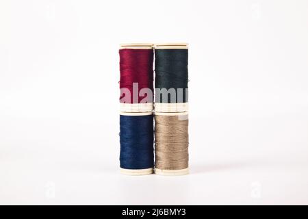 Spools and bobbins of thread for sewing in different colors, isolated on white background Stock Photo