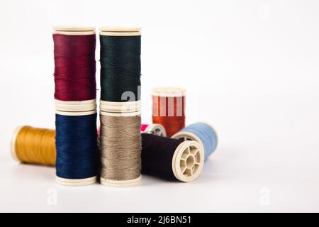 Spools and bobbins of thread for sewing in different colors, isolated on white background Stock Photo