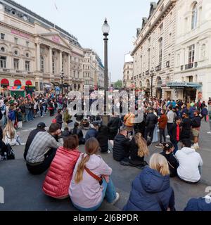 London, Greater London, England, April 23 2022: Crowds gather in Piccadilly Circus to watch street entertainment. Stock Photo