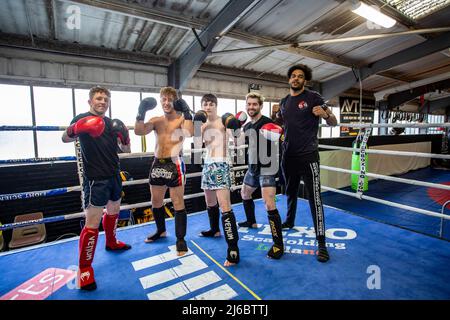 A group of young male Thai Boxing students posing at boxing rig at local gym in West Yorkshire, England. Stock Photo