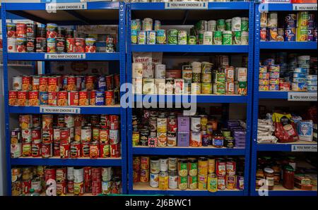 Donated can goods and cereal on shelves at food bank , Wakefiled , England . Stock Photo