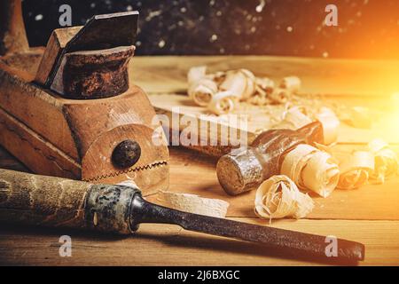 Carpenters tool kit, hammer, chisel and plane on a wooden background with shavings Stock Photo