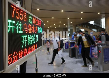 (220430) -- KASHGAR, April 30, 2022 (Xinhua) -- Passengers have their tickets checked to board the train 7558 bound for Urumqi in Hotan Railway Station in Hotan, northwest China's Xinjiang Uygur Autonomous Region, April 28, 2022.  As bullet trains zoom through stations in many parts of China, the seemingly outdated, rumbling slow-speed trains have continued to serve residents of remote areas with stable ticket prices and services.   Though home to the world's most developed high-speed railway network, China still regularly operates 81 slow train services. The trains 7556/7557 and 7558/7555, ru Stock Photo