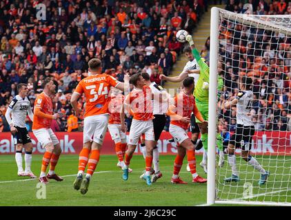 Blackpool goalkeeper Chris Maxwell (second right) punches the ball clear from Derby County's Eiran Cashin during the Sky Bet Championship match at Bloomfield Road, Blackpool. Picture date: Saturday April 30, 2022. Stock Photo