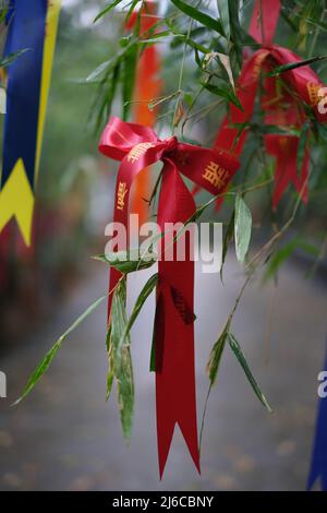 A bundle of colorful bands with best wishes at the entrance to Buddhist temple in Thailand Stock Photo