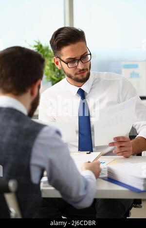 Coworkers men working at financial papers, solve and discuss problems Stock Photo