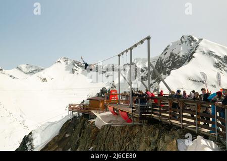 Sochi, Russia - April 23, 2022: Tourists ride on the mega-swing of the Gorki Fly panoramic site at the Krasnaya Polyana ski resort Stock Photo