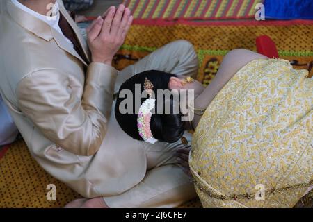 Thai wedding: the bride bows her head before the praying groom Stock Photo