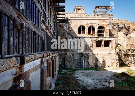 Industrial ruins - dilapidated buildings of the former mining settlement Argentiera on the west coast of Nurra, Sassari, Sardinia, Italy Stock Photo