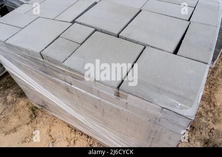 Laying of gray concrete paving slabs in the house courtyard driveway patio. Professional working masons install new tiles or slabs for the driveway, s Stock Photo