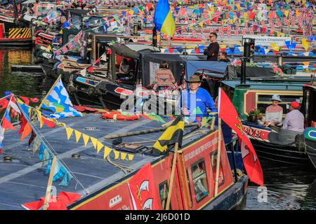 London, UK, 30th April 2022. Dozens of beautifully decorated narrowboats, barges and canal boats take part in the IWA Canalway Cavalcade festival which returns to London’s Little Venice for the early May Bank Holiday weekend. Organised by the Inland Waterways Association (IWA), it celebrates boat life with a boat pageant, as well as music, stalls and family entertainment along the Grand Union Canal. Stock Photo