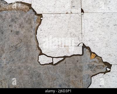 Remnants of cracked linoleum tile floor Stock Photo