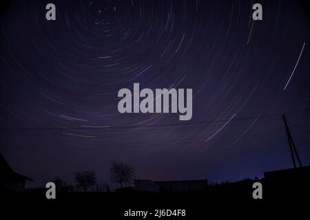 The total time interval of star trails in the night sky. Polar star exposure Stock Photo