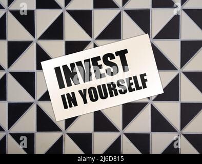 Invest in Yourself words on card on wooden table. Business education concept Stock Photo