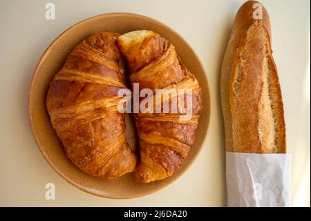 Summer morning in Provence, traditional breakfast with fresh baked croissants and baguette bread close up Stock Photo