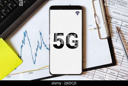Model airplane on geographic map and smartphone with 5G text on screen. Conceptual image for concerns about possible transmission interference to airc Stock Photo