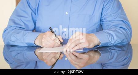 A businessman signs a contract on desk. Stock Photo