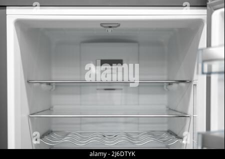 Empty fridge background, inside view into the refrigerator with glassy shelfs, food storage concept. Inside of clean and empty refrigerator with shelv Stock Photo