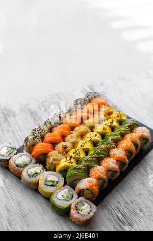 Sushi Set nigiri and sushi rolls on black stone slate plate board. place for tex. instagram stories