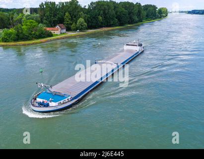 Aerial top down view on inland   commercial ship cross the River Rhine. Drone photography. Stock Photo