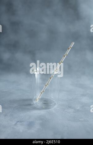 https://l450v.alamy.com/450v/2j6e510/transparent-glass-with-a-paper-tube-on-a-gray-background-2j6e510.jpg