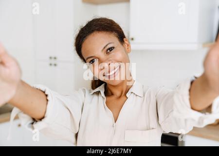 Young black woman smiling while taking selfie photo at home Stock Photo