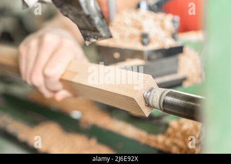 Crop handyman operating wood turning machine at work Stock Photo
