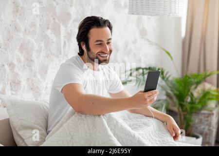 Positive handsome guy having video call in the morning Stock Photo