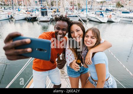 Happy multiracial young friends talking selfie with cellphone Stock Photo