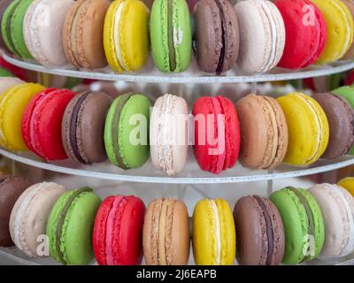 Colorful homemade macarons, dessert on round shelf, close-up. Different color of macaroon background. Tasty sweet color macaron medal decoration in ba Stock Photo