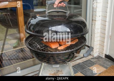 Smoking salmon the cold way on a barbecue outside in winter Stock Photo