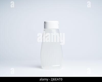 A white matte plastic bottle curved shape with dispenser for sauces isolated on white background, front view with empty space on it and no label, phot Stock Photo