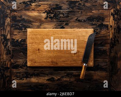 Butcher. Vintage meat knife on cutting board over wooden table Stock Photo