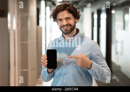 Businessman pointing at black empty smartphone screen Stock Photo