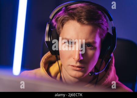 Guy cyber sportsman streaming while playing shooting game Stock Photo